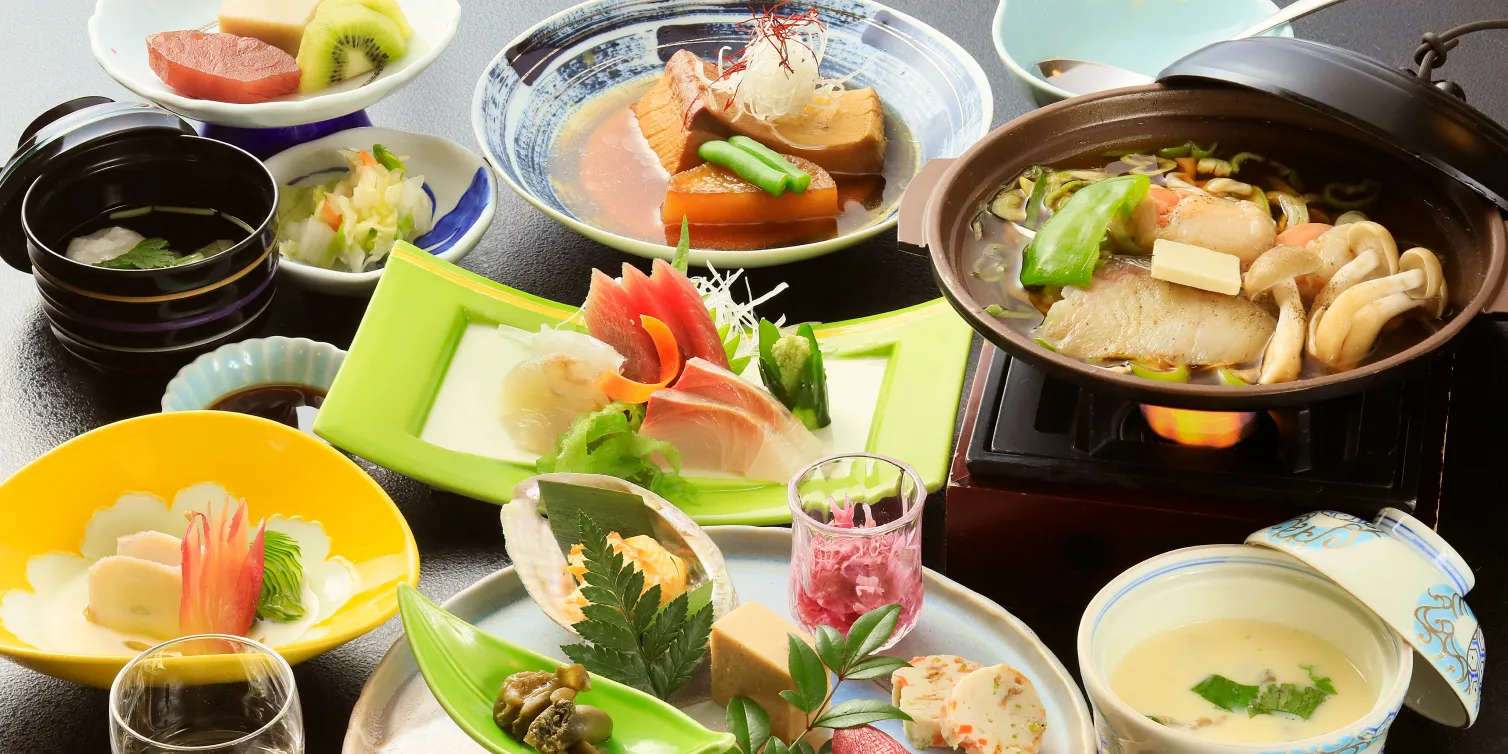 鍋料理や刺身、旬の小鉢が並ぶ夕食。