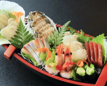 豪華な舟盛り。新鮮な魚介類が船の形をした器に盛り付けられている。