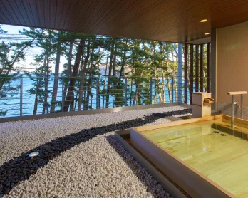 木造の露天風呂から、目の前の松林と根浜海岸の絶景が広がる。雄大な景色を眺めながら、波の音に癒される開放的な空間。