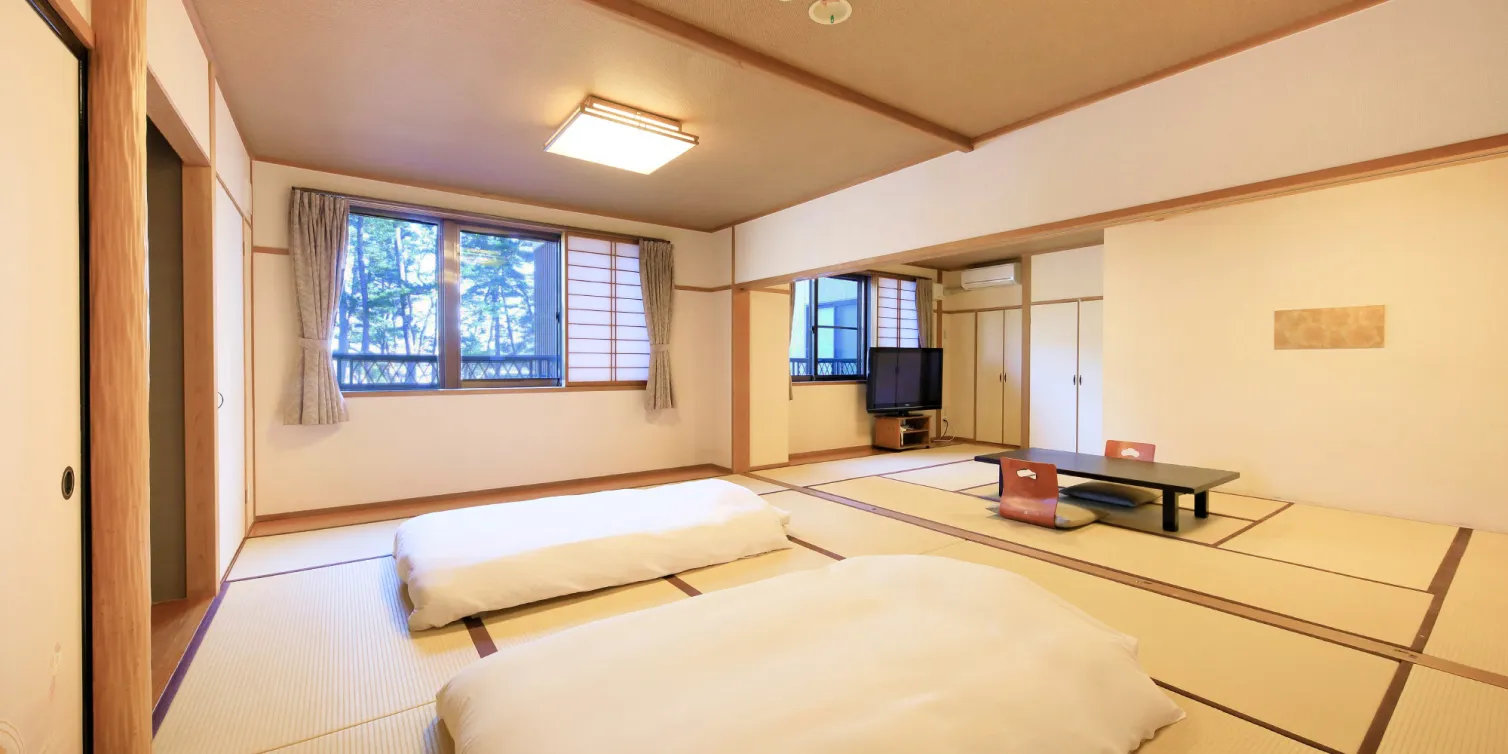畳敷きの部屋で、窓の外に木々が見える。